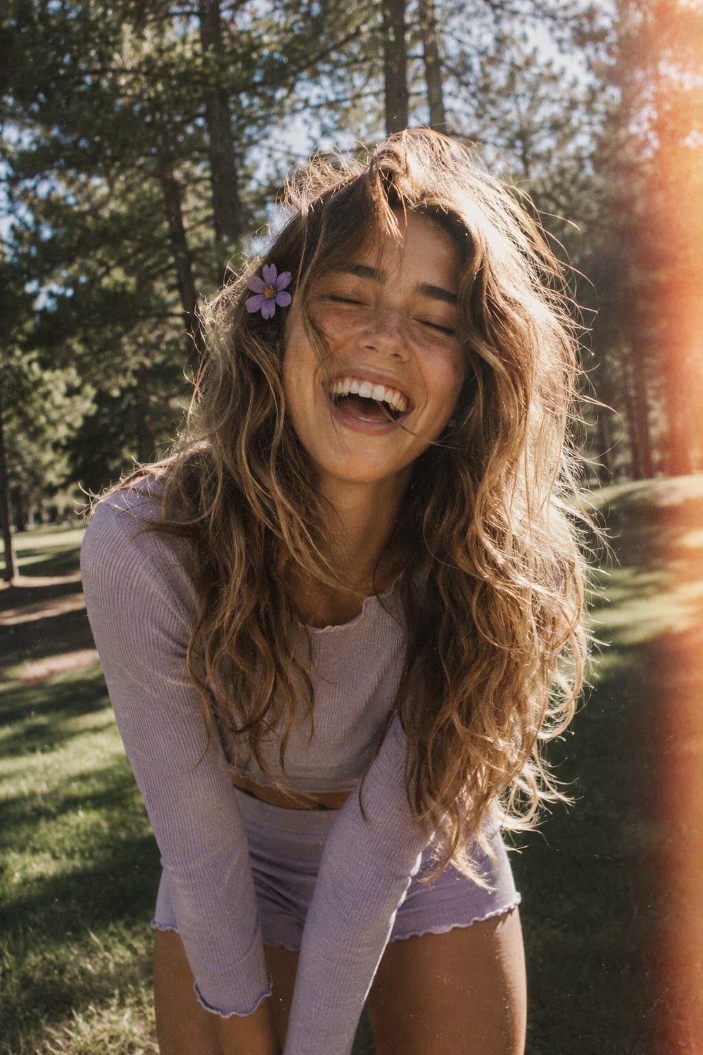 A candid, film-style portrait of a joyful young woman with long, voluminous, wavy light brown…
